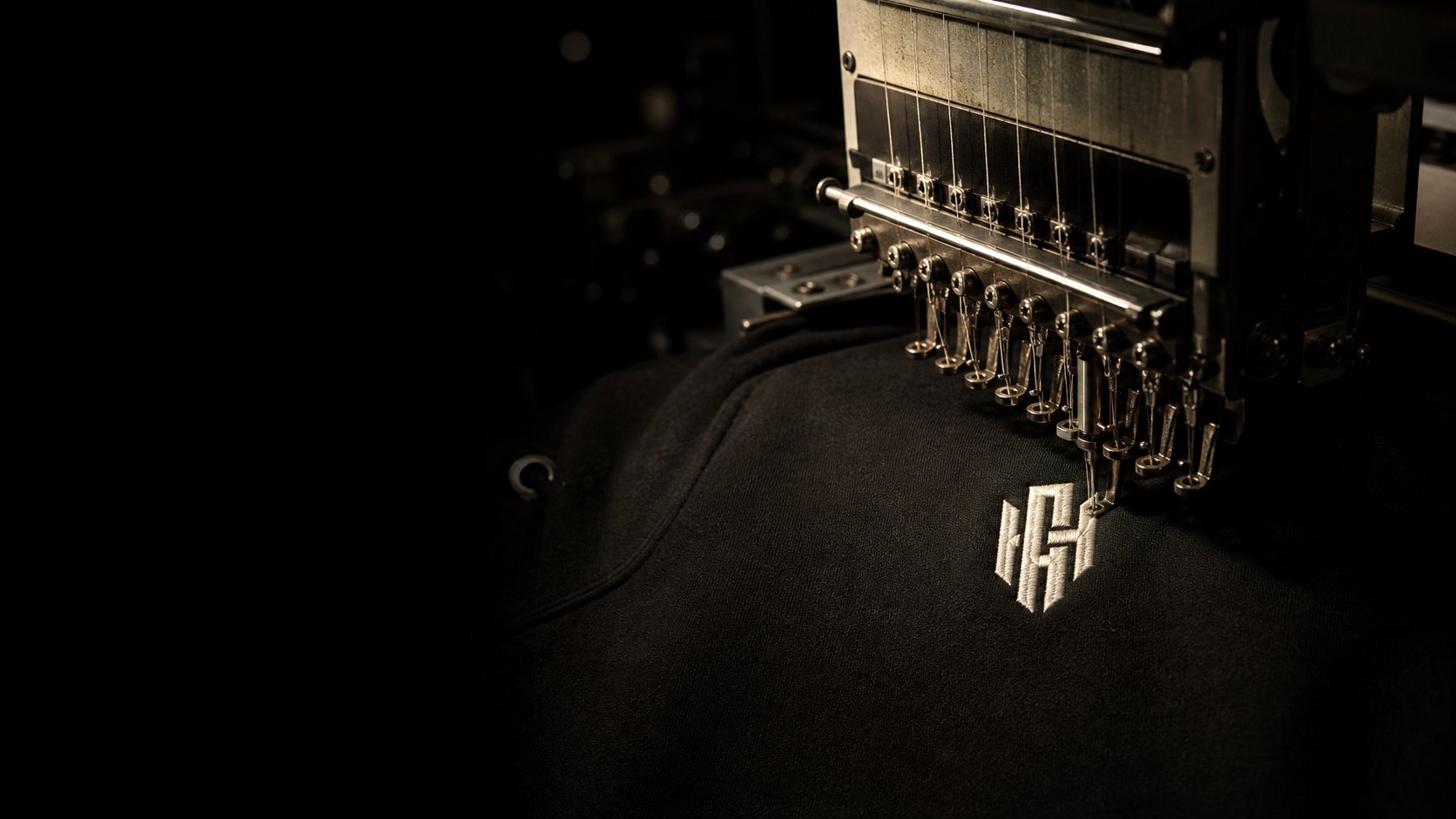 Embroidery machine over a black hoodie carrying the Hayes Apparel mark