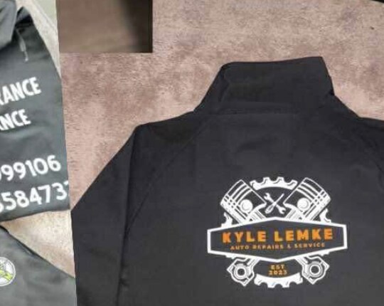 A black jacket with a detailed automotive repair logo on the back